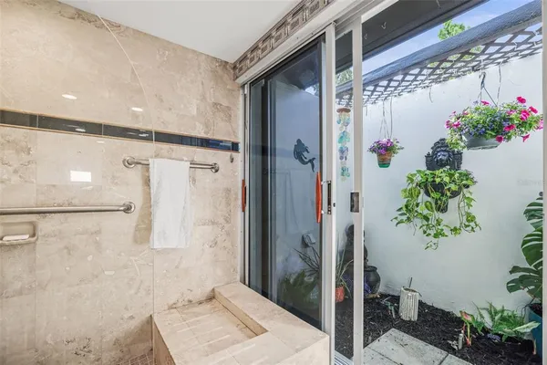 a bathroom with a potted plant and a shower