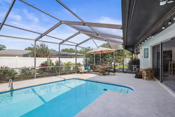 a view of a backyard with a table and chairs under an umbrella