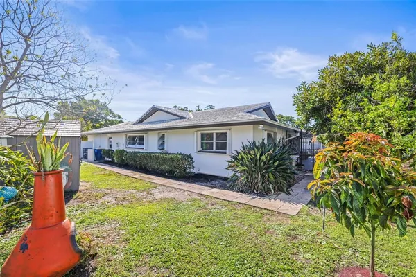 a front view of a house with a yard and potted plants