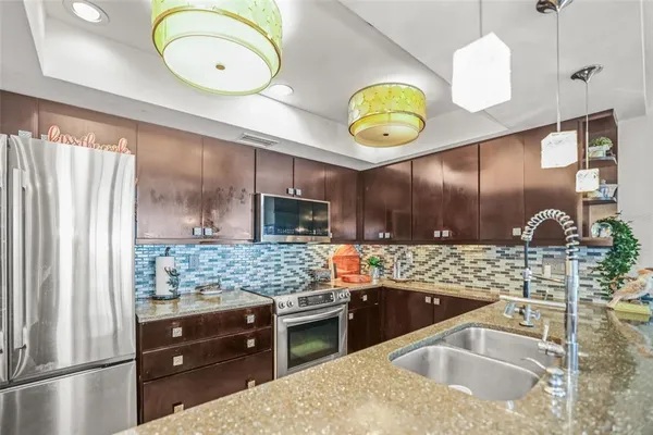 a kitchen with stainless steel appliances granite countertop a sink and a stove