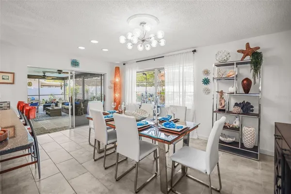 a dining room with furniture a chandelier and window