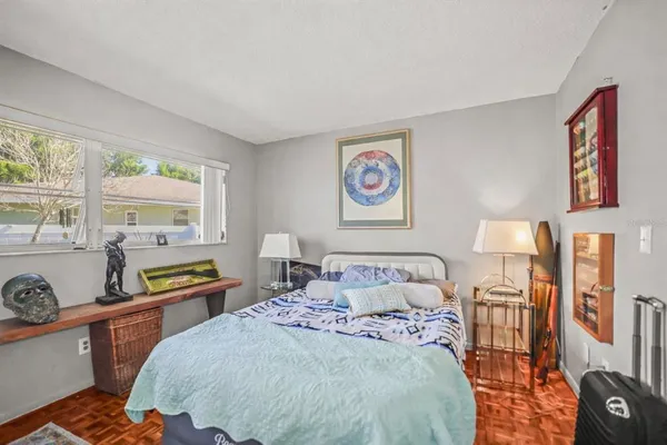 a bedroom with a bed and wooden floor