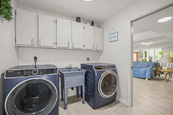 a utility room with sink dryer and washer