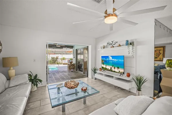 a living room with furniture a flat screen tv and a potted plant