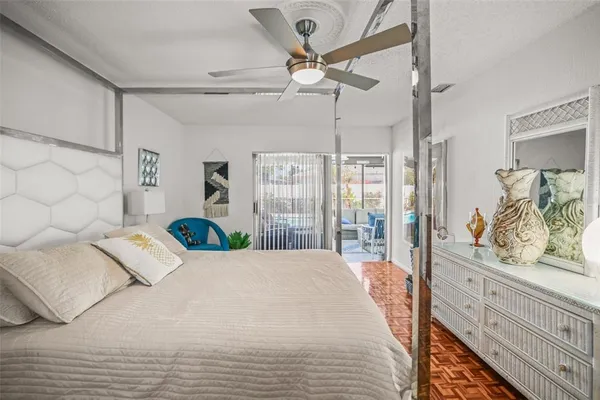 a bedroom with a large bed and a chandelier fan