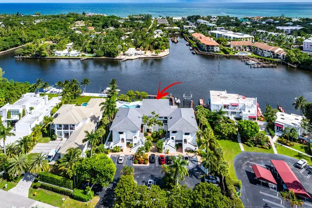 a view of a hallway with wooden floor and a refrigerator