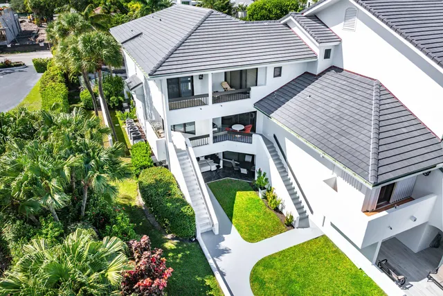 a view of a white house with palm trees