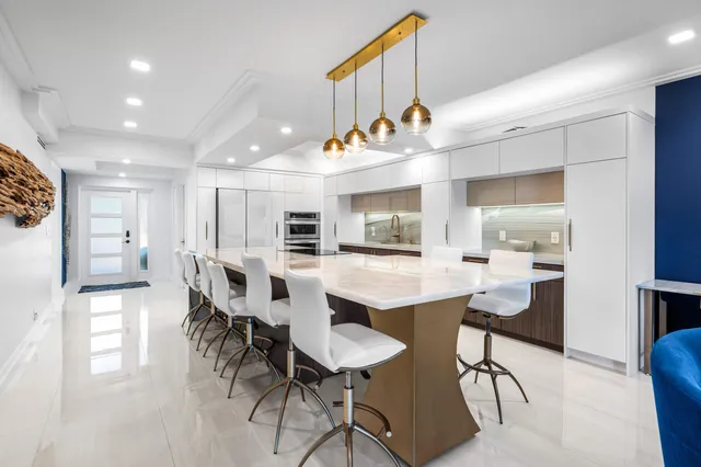 a kitchen with stainless steel appliances kitchen island a table chairs in it and wooden floors