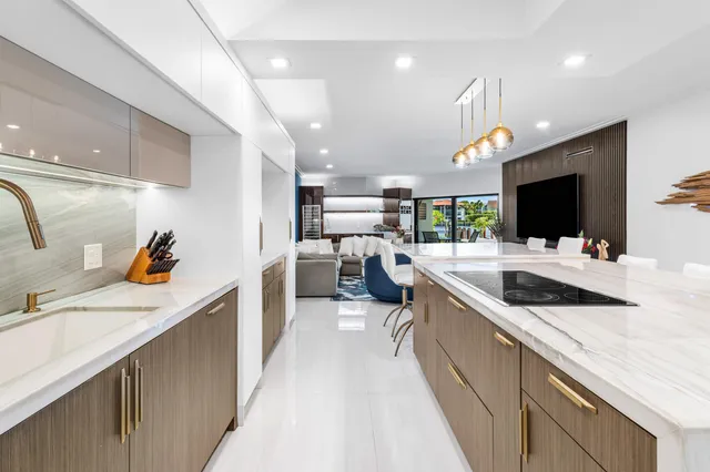 a living room with furniture kitchen view and a flat screen tv