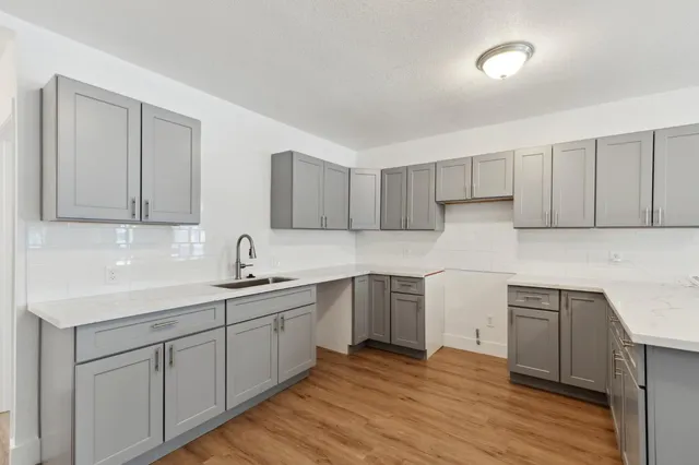 a kitchen with sink cabinets and wooden floor
