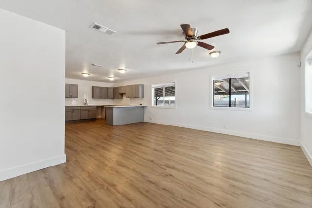 a view of empty room with wooden floor and windows