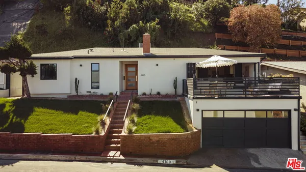 a view of a house with a yard potted plants