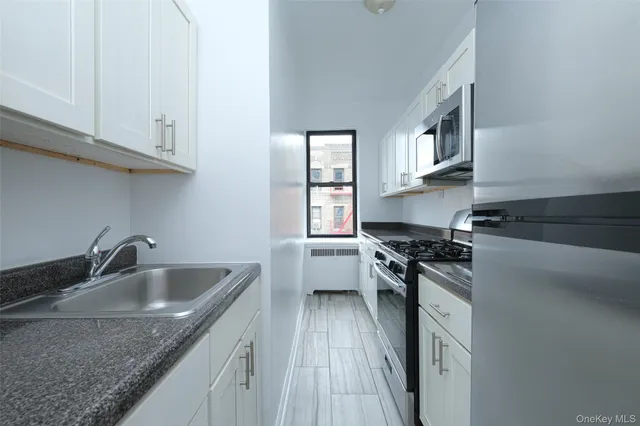 a kitchen with granite countertop a sink dishwasher stove and cabinets