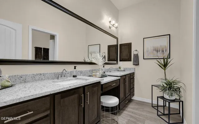 a bathroom with a granite countertop sink a mirror and a toilet