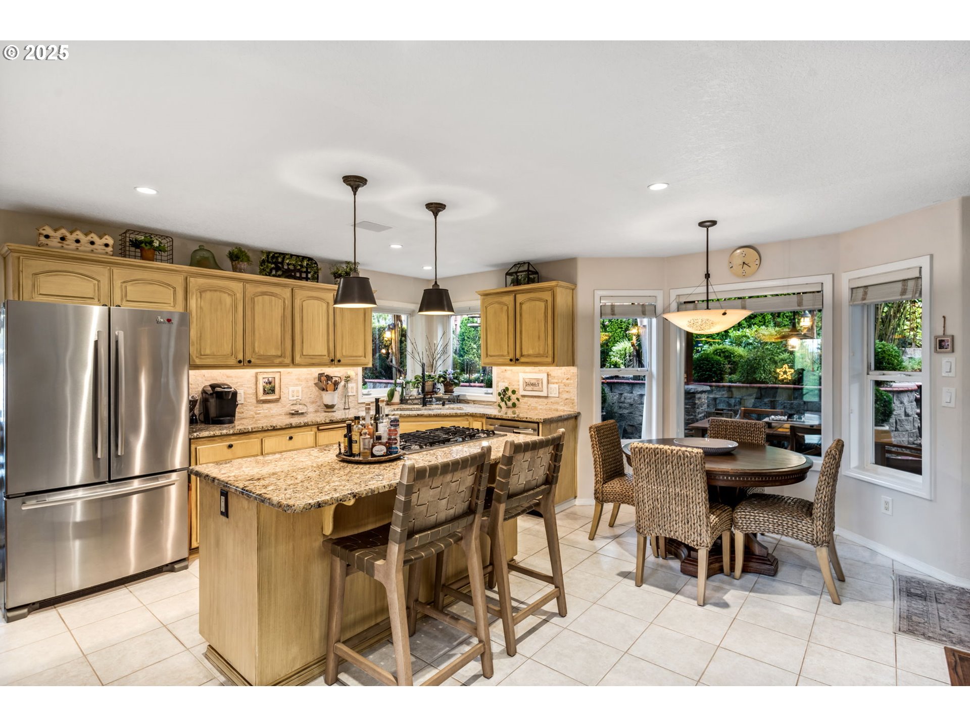 12176 Southwest Ames Lane Portland, OR 97224 - Photo 11 of 46 a kitchen with stainless steel appliances kitchen island granite countertop a table chairs stove and refrigerator