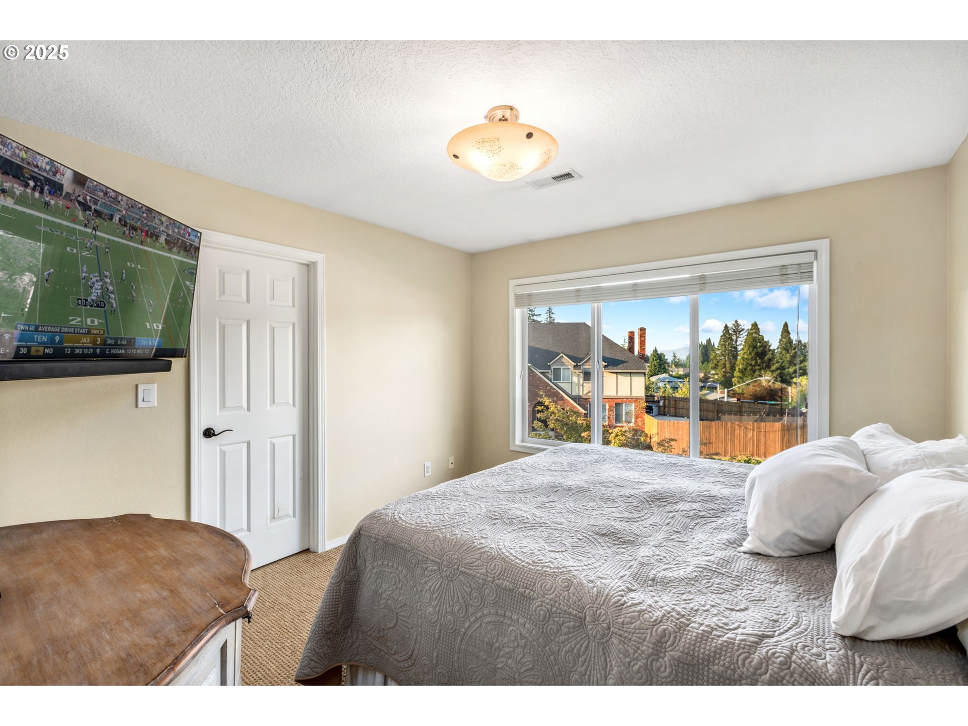 12176 Southwest Ames Lane Portland, OR 97224 - Photo 32 of 46 a bedroom with a large bed and a chandelier