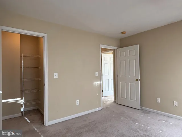 a view of an empty room with glass door and a bathroom