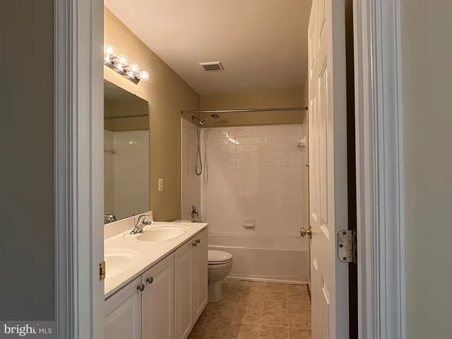 a bathroom with a double vanity sink and mirror with shower
