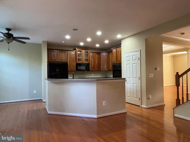 a view of kitchen with kitchen island wooden floor center island and stainless steel appliances