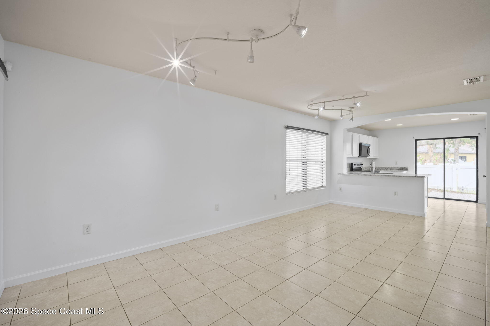 4555 Radiant Way, Unit 103 Melbourne, FL 32901 - Photo 11 of 58 a view of empty room with wooden floor and window