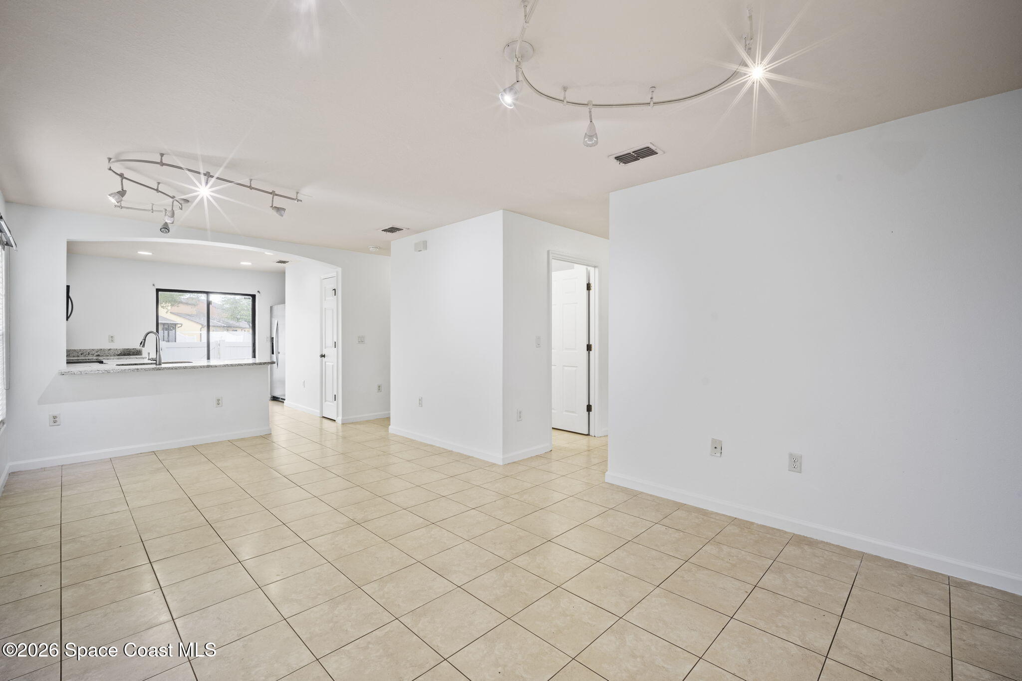 4555 Radiant Way, Unit 103 Melbourne, FL 32901 - Photo 12 of 58 a view of an empty room and chandelier fan