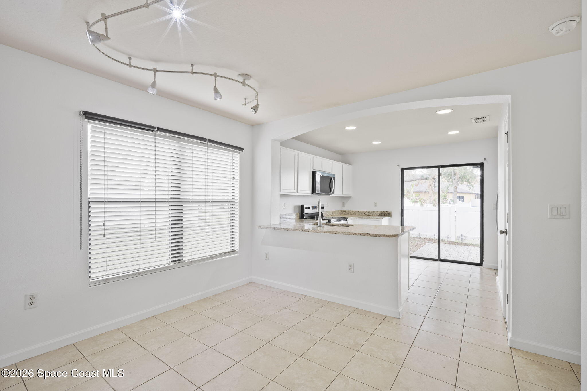 4555 Radiant Way, Unit 103 Melbourne, FL 32901 - Photo 16 of 58 a large white kitchen with a white cabinets and a window