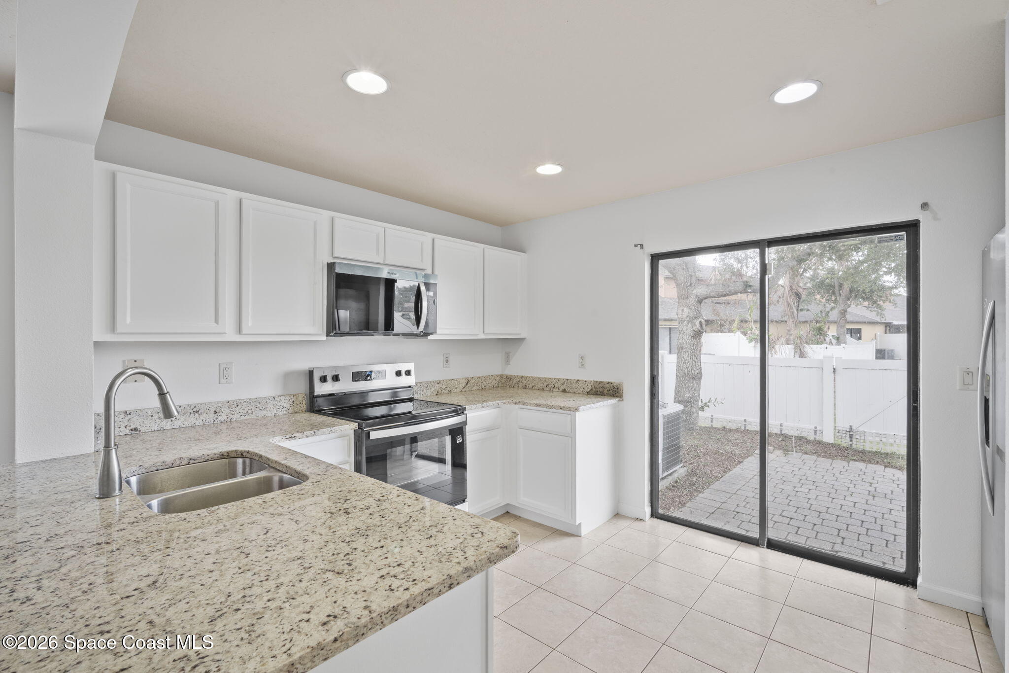 4555 Radiant Way, Unit 103 Melbourne, FL 32901 - Photo 18 of 58 a kitchen with granite countertop a stove a sink and a microwave
