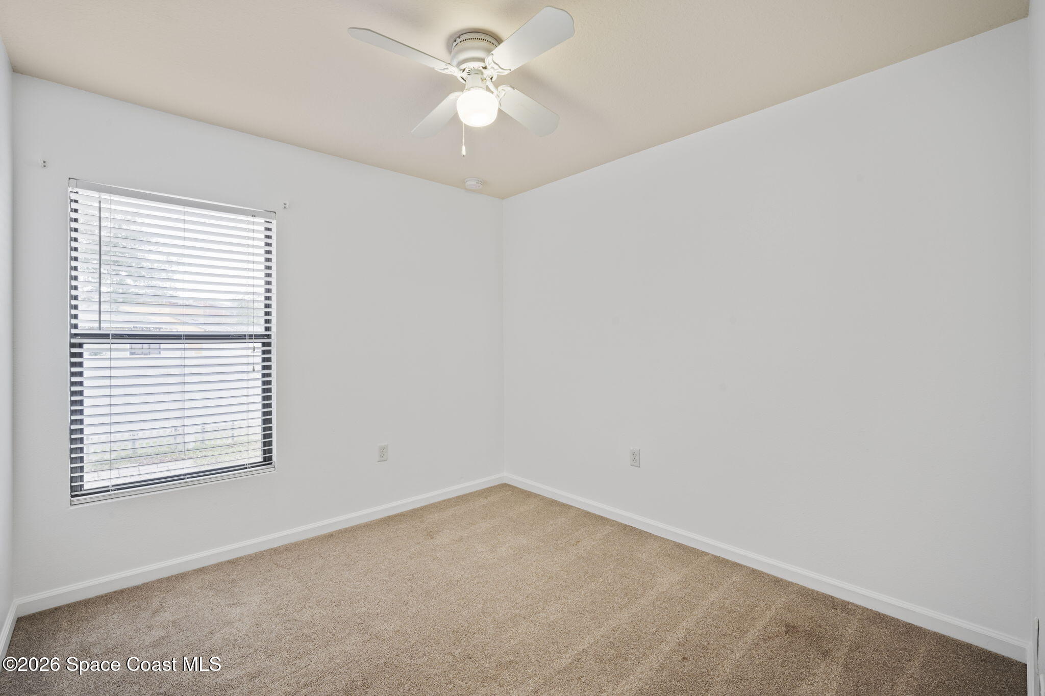 4555 Radiant Way, Unit 103 Melbourne, FL 32901 - Photo 20 of 58 an empty room with a window and a ceiling fan