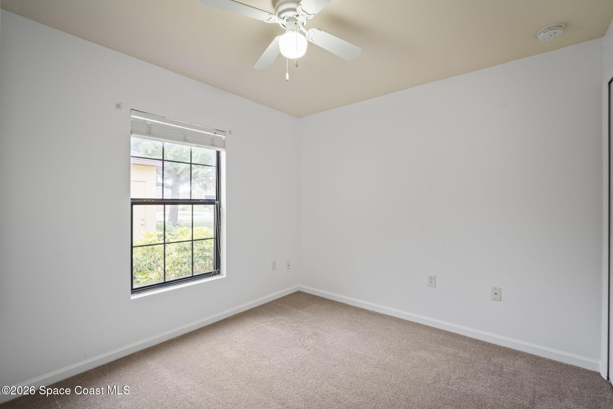 4555 Radiant Way, Unit 103 Melbourne, FL 32901 - Photo 23 of 58 an empty room with a window and a chandelier fan