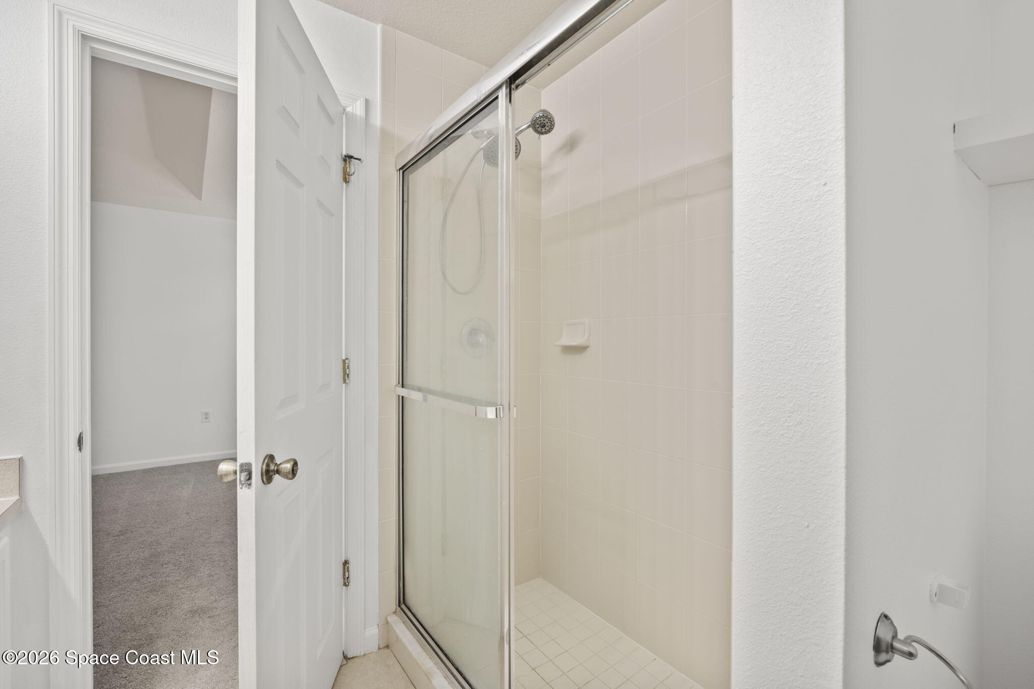 4555 Radiant Way, Unit 103 Melbourne, FL 32901 - Photo 36 of 58 a bathroom with a glass shower door