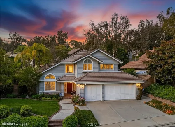 a front view of a house with a yard and trees
