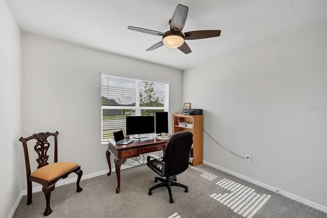 a view of a workspace with furniture and a window