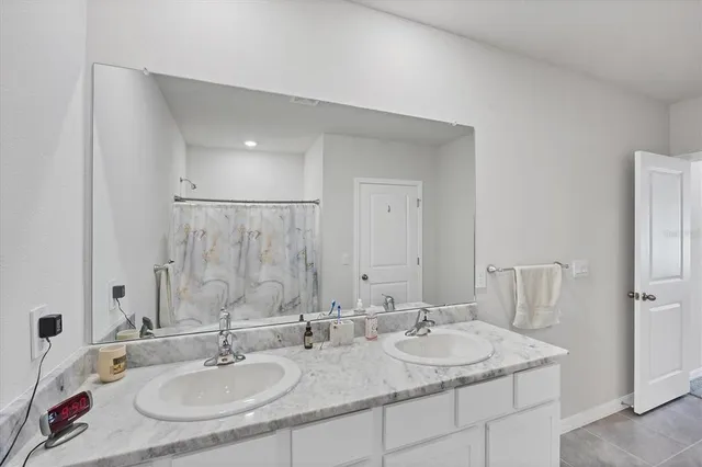 a bathroom with double sink and a mirror