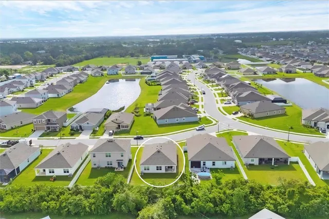 an aerial view of residential houses with outdoor space and swimming pool