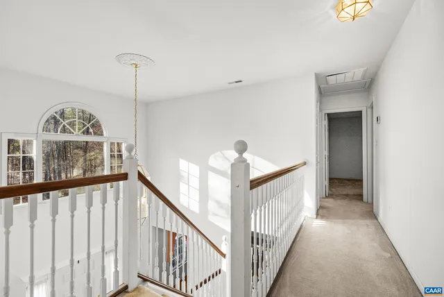 a view of a house with a big yard and large trees