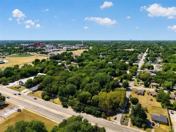 an aerial view of residential houses with outdoor space and trees