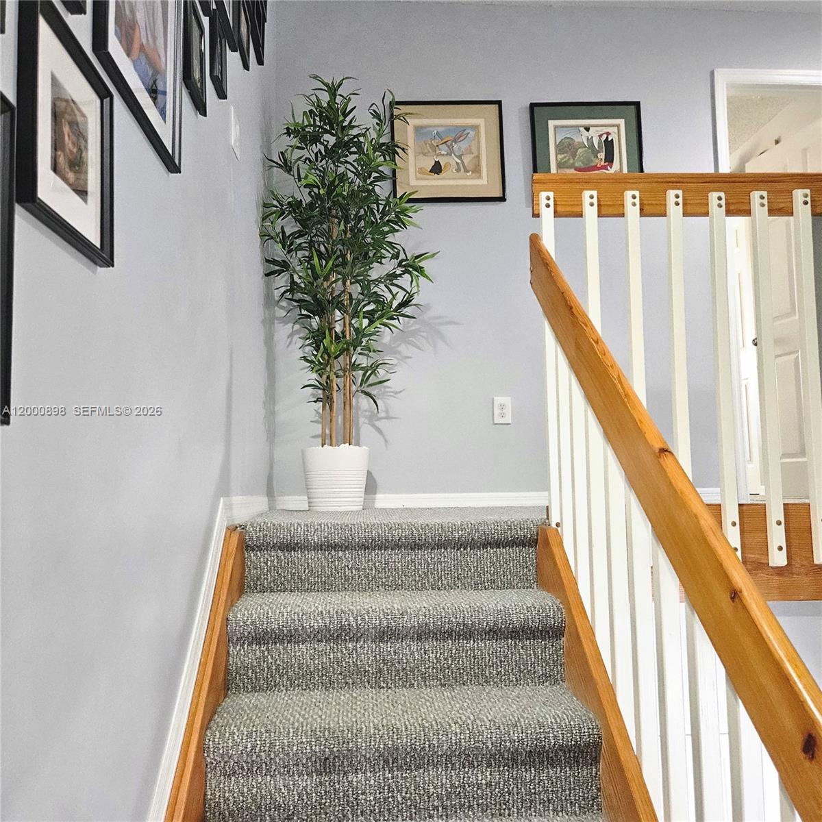 7378 Southwest 162nd Place Miami, FL 33193 - Photo 15 of 37 a view of staircase with lots of frames on wall and a window