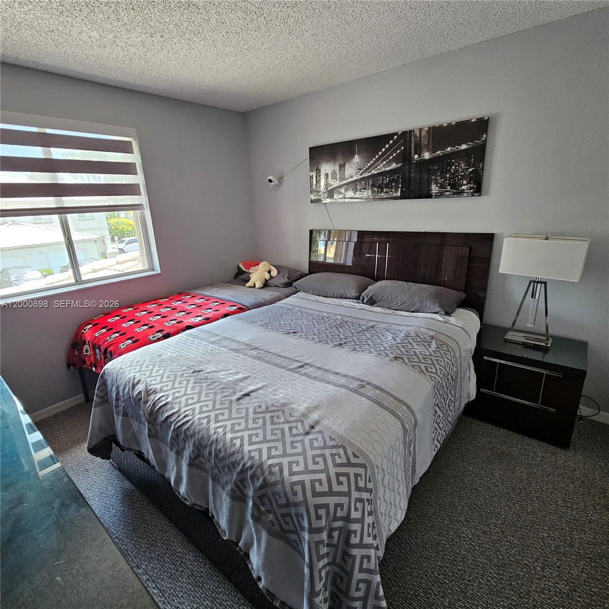 7378 Southwest 162nd Place Miami, FL 33193 - Photo 22 of 37 a bedroom with a bed and window