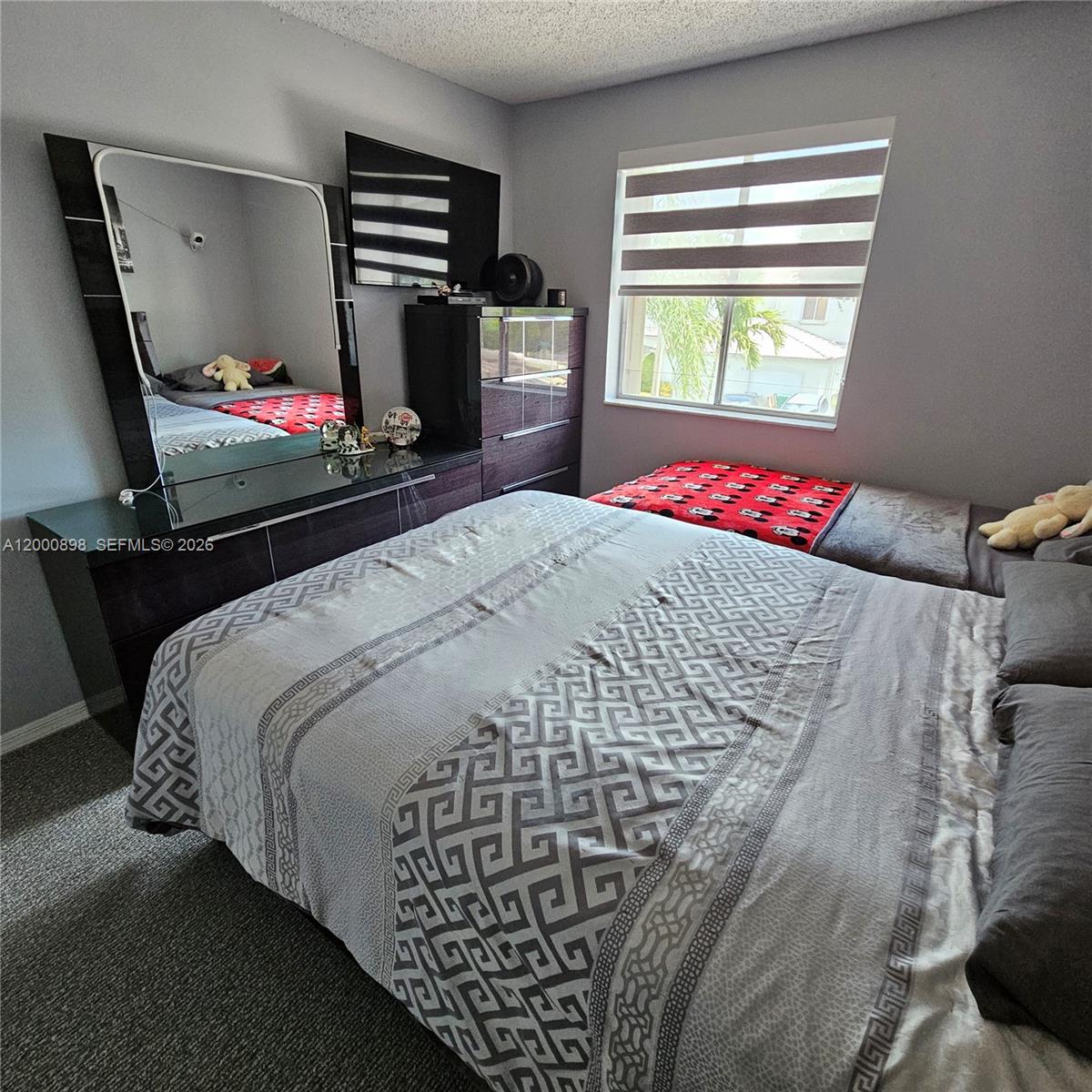 7378 Southwest 162nd Place Miami, FL 33193 - Photo 23 of 37 a bed sitting in a bedroom next to a window