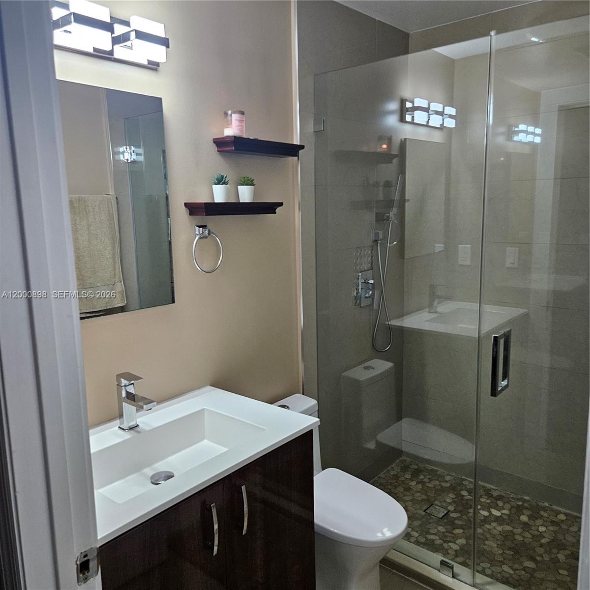 7378 Southwest 162nd Place Miami, FL 33193 - Photo 24 of 37 a bathroom with a sink a toilet a shower and a mirror
