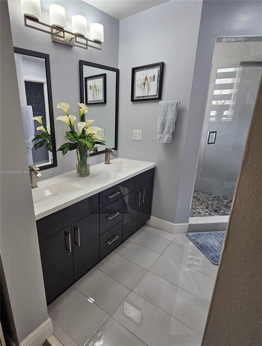 7378 Southwest 162nd Place Miami, FL 33193 - Photo 28 of 37 a spacious bathroom with a granite countertop sink and a mirror