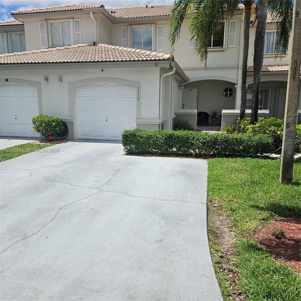 7378 Southwest 162nd Place Miami, FL 33193 - Photo 4 of 37 a front view of a house with a yard and potted plants