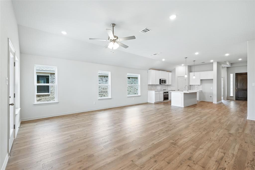 3704 Pitchfork Terrace Anna, TX 75409 - Photo 9 of 31 a view of an empty room with wooden floor and a kitchen space