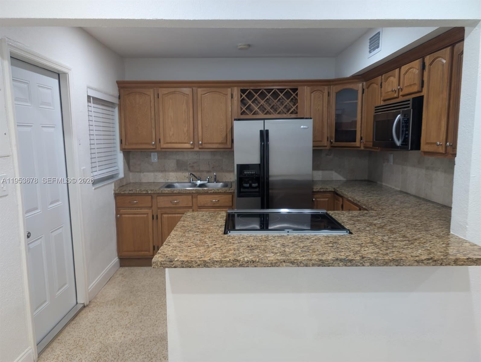 a kitchen with kitchen island granite countertop a sink a stove and a refrigerator