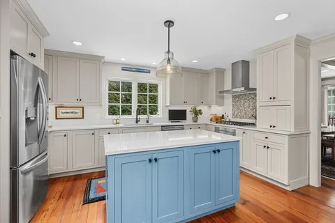 a kitchen with stainless steel appliances granite countertop a sink cabinets and wooden floor