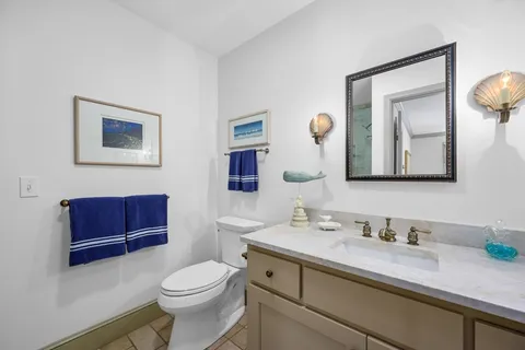 a bathroom with a toilet a sink a vanity a mirror and vanity