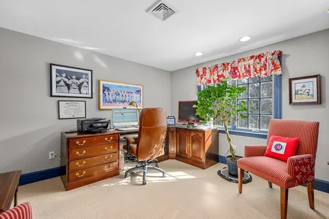 a view of a workspace with furniture and a window
