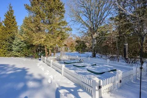a view of backyard with table and chairs and wooden fence
