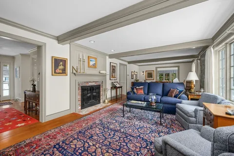 a living room with furniture mirror and a fireplace