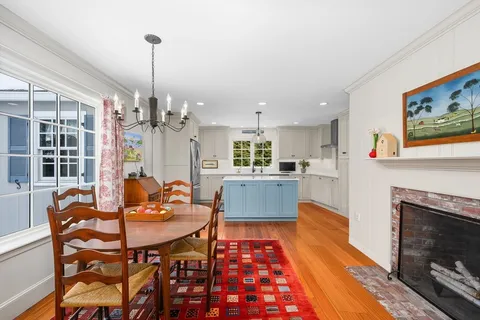 a living room with dining table a rug and kitchen view
